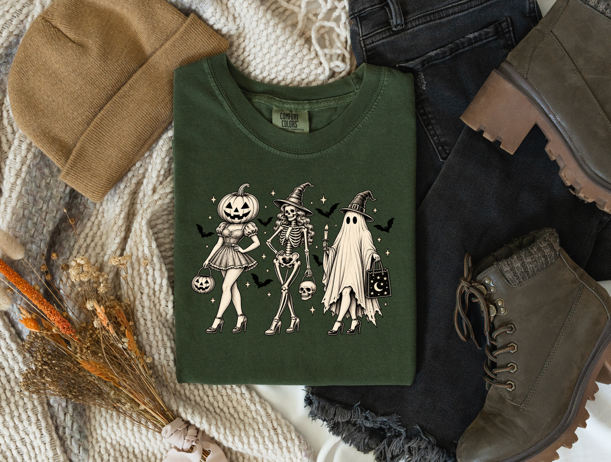 Vintage pumpkin, skeleton witch, and ghost trio graphic on a dark green tee